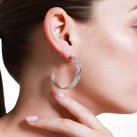 Silber Feder-Ohrring elegant präsentiert am Ohr