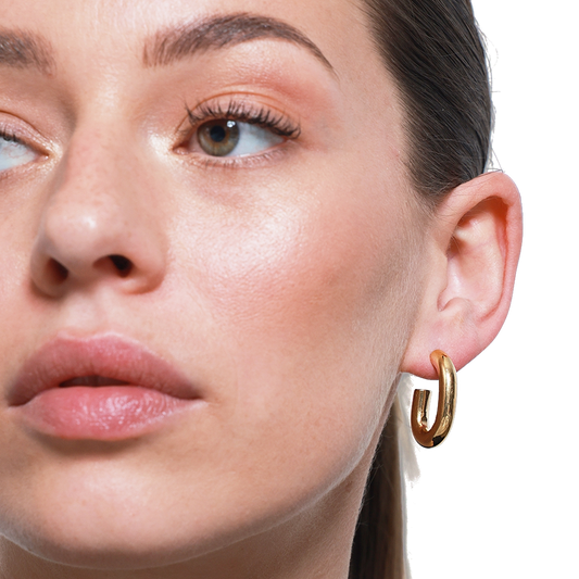 Stilvolles Porträt mit modernem Gold-Ohrring und Make-up